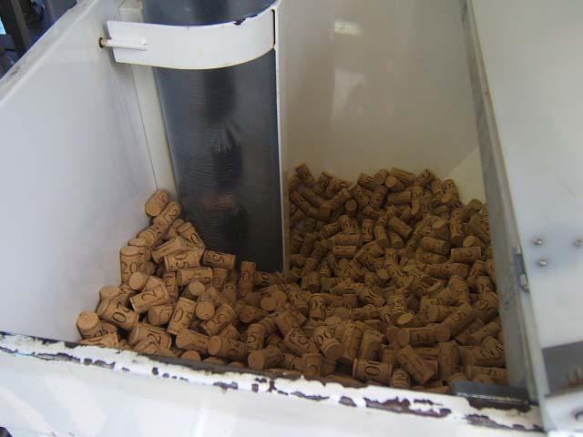 meb15.JPG - Bac d'alimentation en bouchons : ils montent dans le réservoir de la boucheuse par une vis sans fin en brosse.