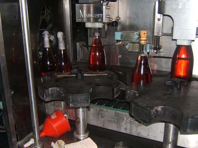 deg05.JPG - Pose du bouchon : cylindrique à l'origine, le bouchon est fortement compressé et enfoncé à moitié dans le goulot.