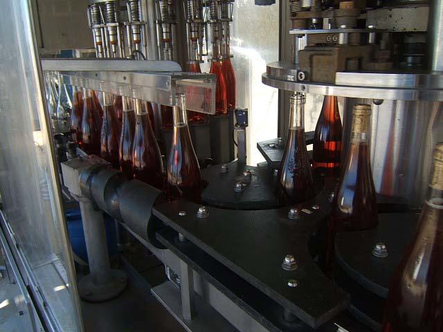 meb16.JPG - Transfert des bouteilles de la tireuse à la boucheuse.