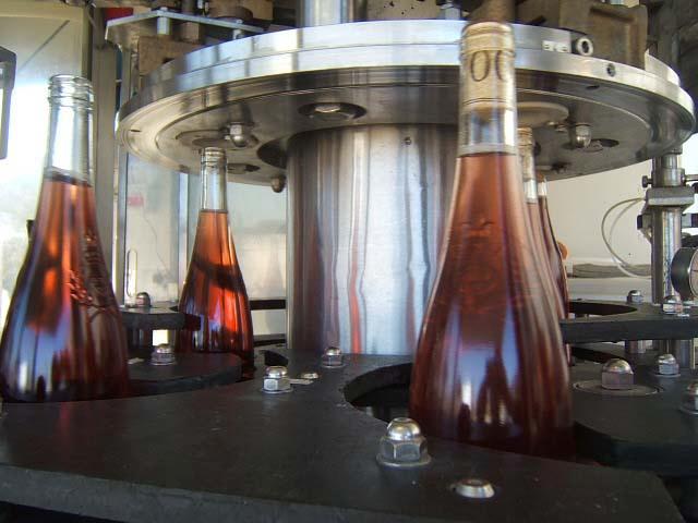 meb17.JPG - Boucheuse rotative sous vide à trois têtes, permettant à l'ensemble  de fonctionner à une cadance de plus de 3000 bouteilles à l'heure . Le vide réalisé dans la bouteille avant le bouchage permet de limiter les bouteilles couleuses.
